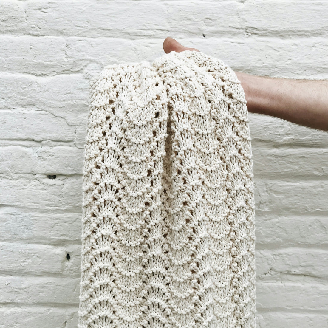 person holding white knit textile