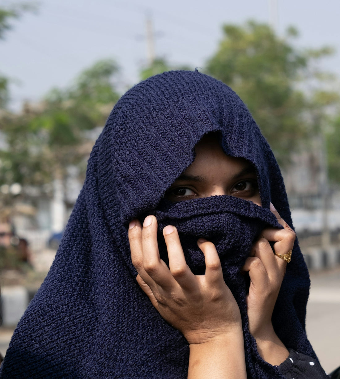 a woman covering her face with a scarf