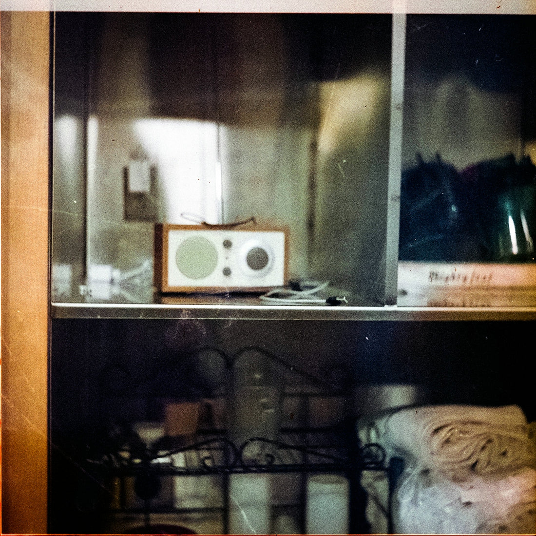 Retro radio on a shelf with items below.