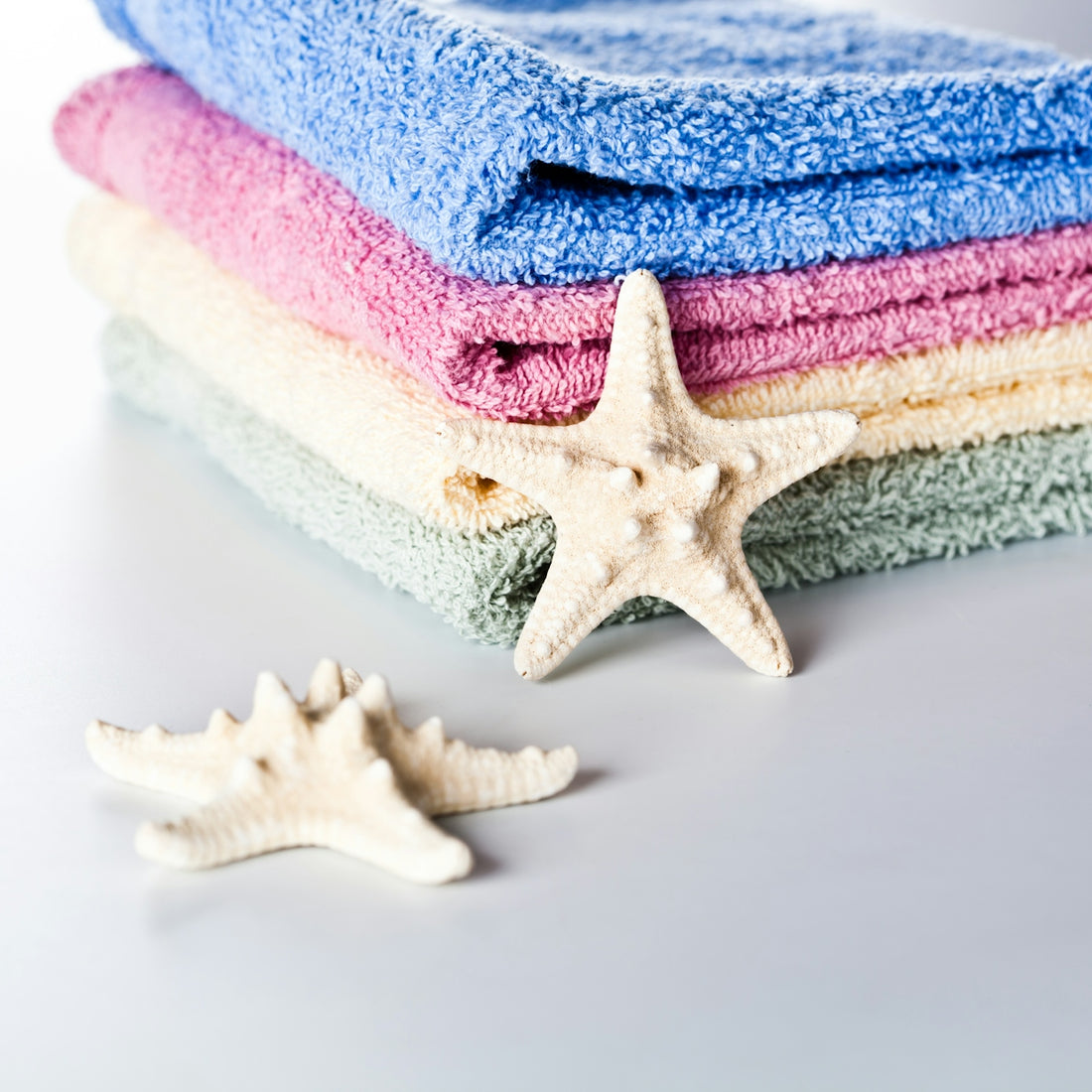 A stack of towels and a starfish on a table