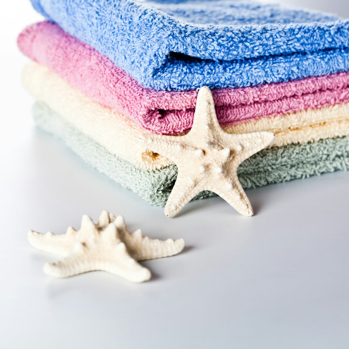 A stack of towels and a starfish on a table