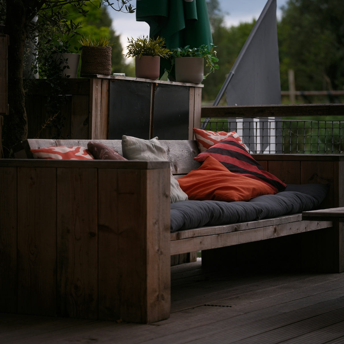 Wooden outdoor sofa with colorful pillows