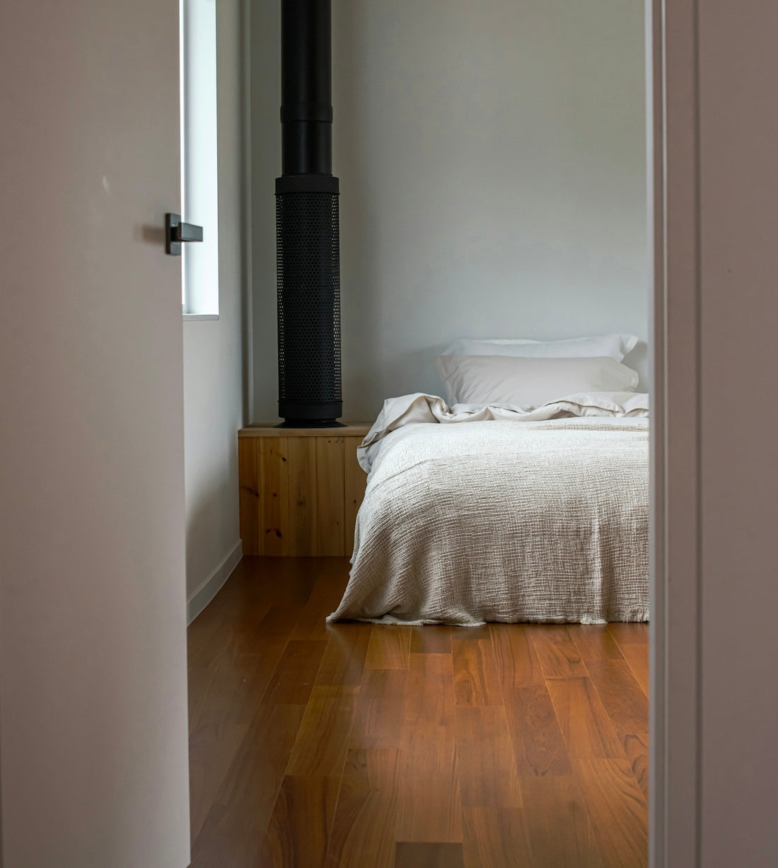 A cozy bedroom with a fireplace and wooden floor.