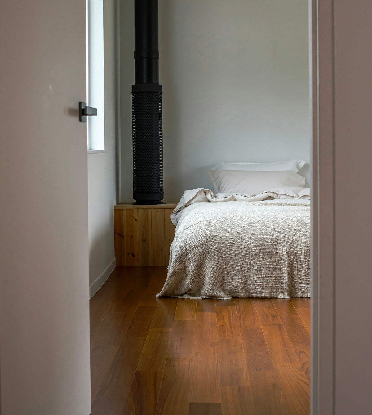 A cozy bedroom with a fireplace and wooden floor.