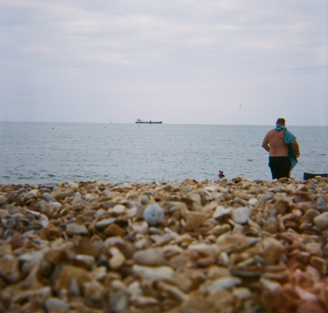 Person on a pebble beach looking at the sea