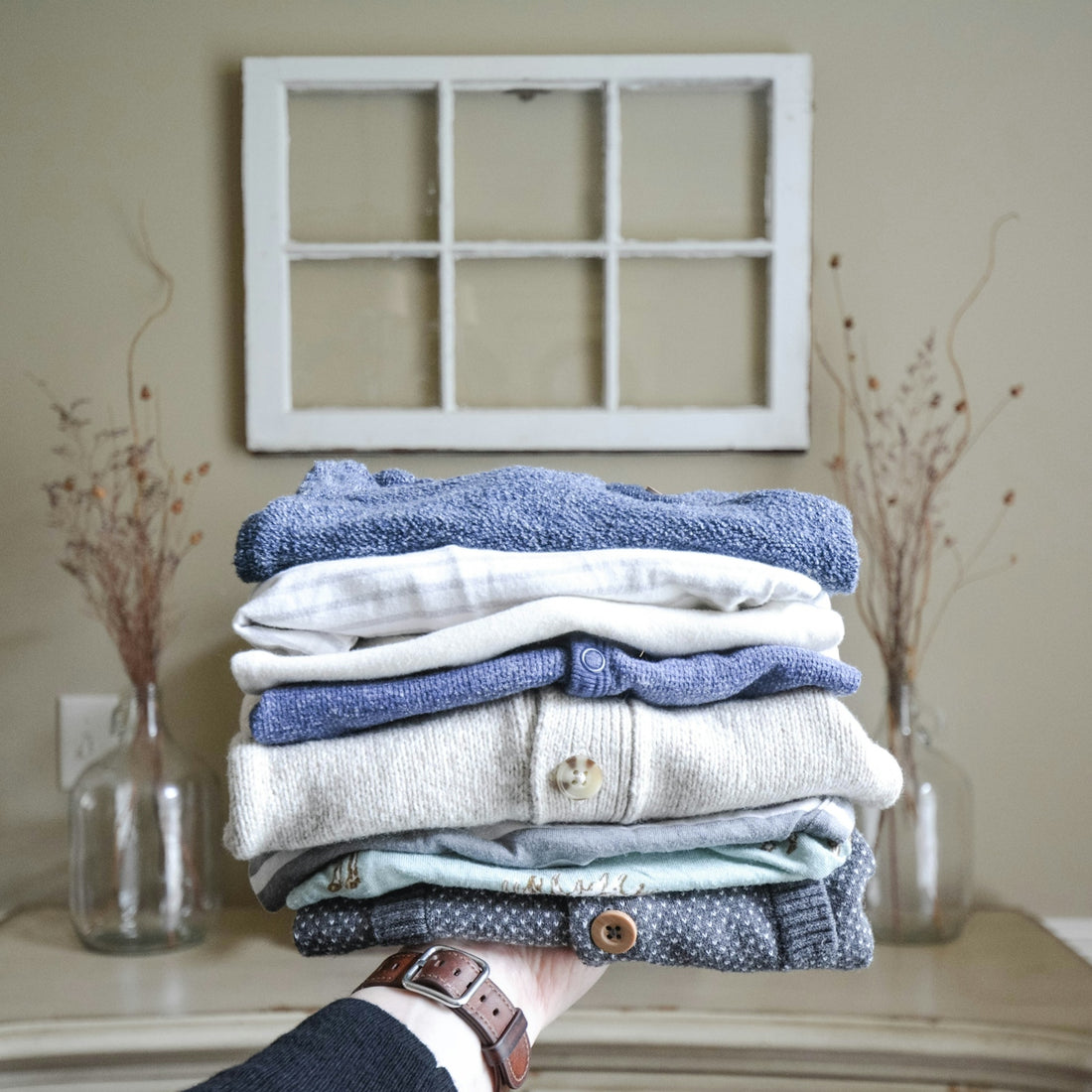 Stack of folded clothes held by a hand