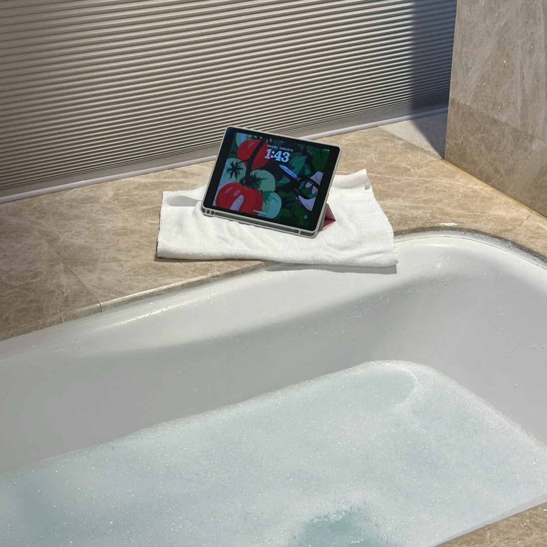 Tablet displaying colorful art on a bathtub tray