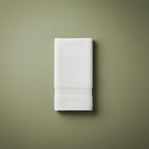 White folded hand towel on a green background