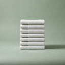 Stack of white towels on a light green background