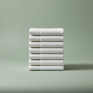 Stack of white towels on a light green background